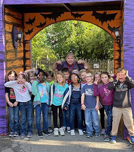 Students making faces in front of a gate with bats on it